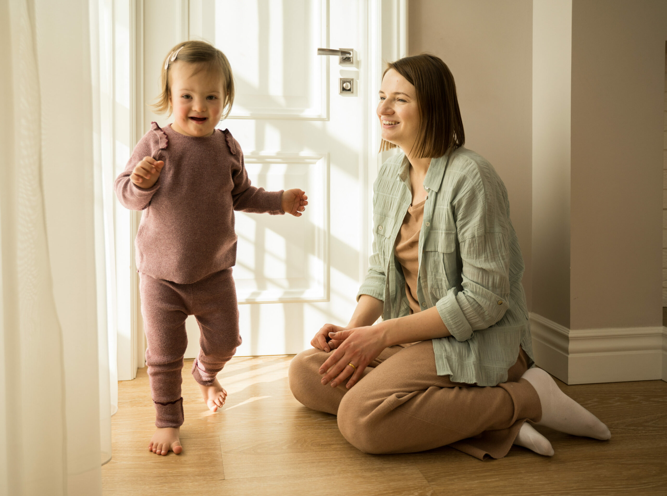 Mother playing with her daughter with down syndrome at their apartments