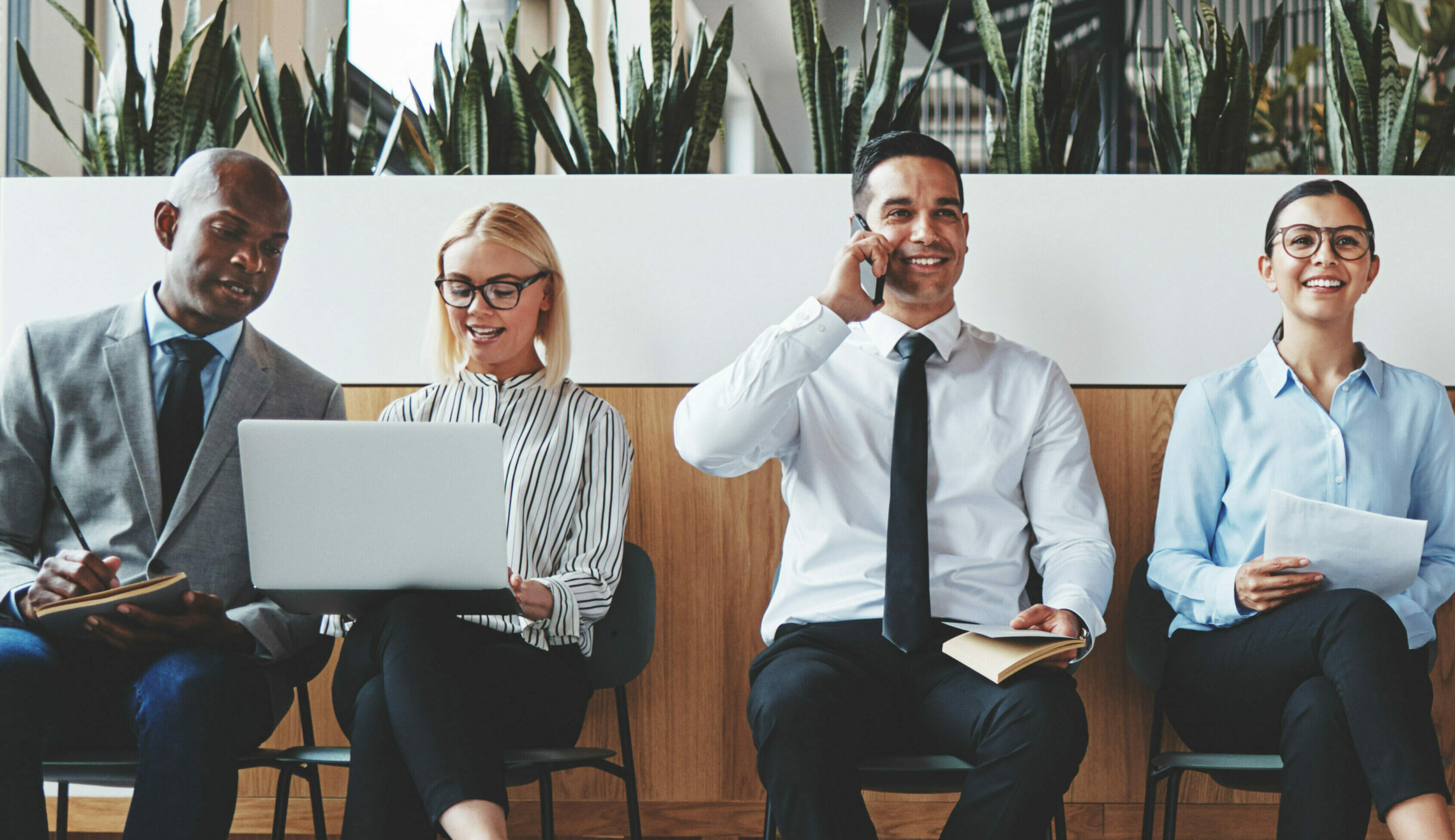 Smiling group of diverse businesspeople waiting in an office rec